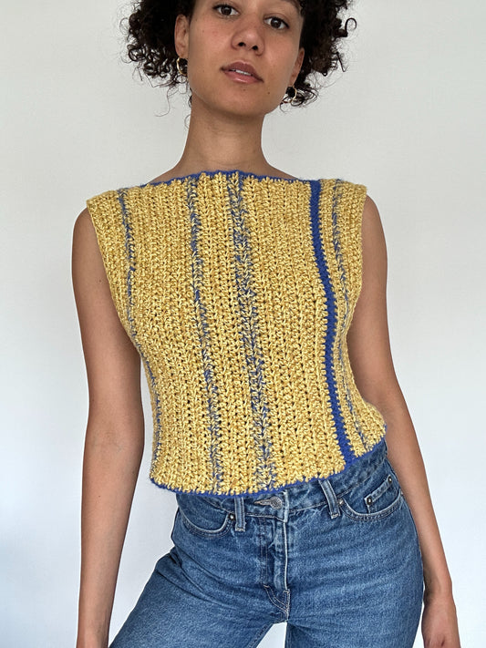 Shows a model wearing a yellow and blue crocheted NIMA Tank Top made by The Woollers