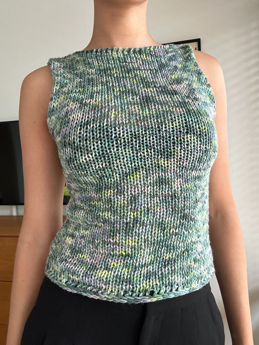 Shows a model wearing our knitted multi-colored 'iris' tank top in shades of green, blue and pink. Made by The Woollers