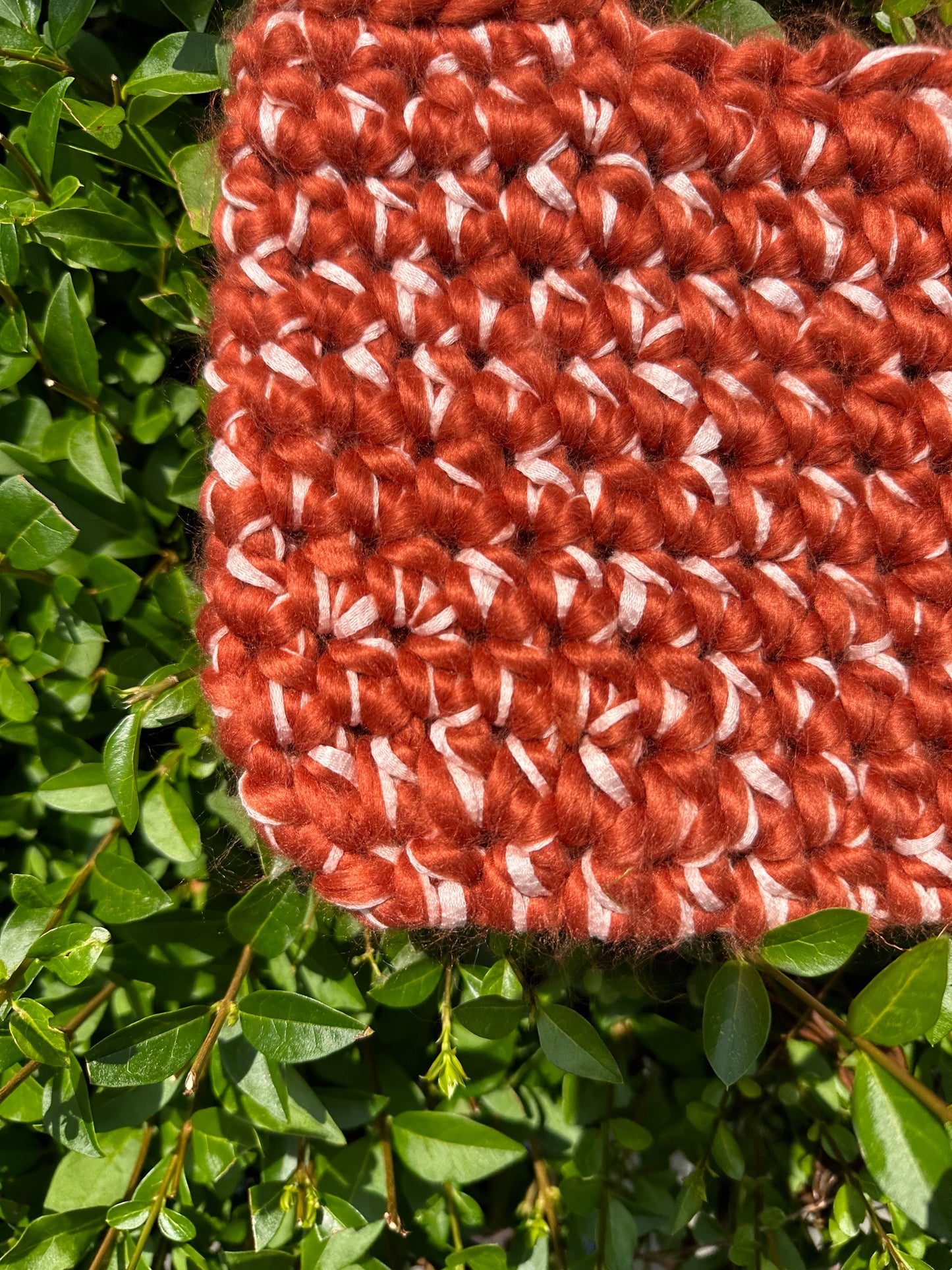 Shows a close up of the fabric of a crocheted blood orange red and rose pink FLUFFY LINT Handbag. Made by The Woollers