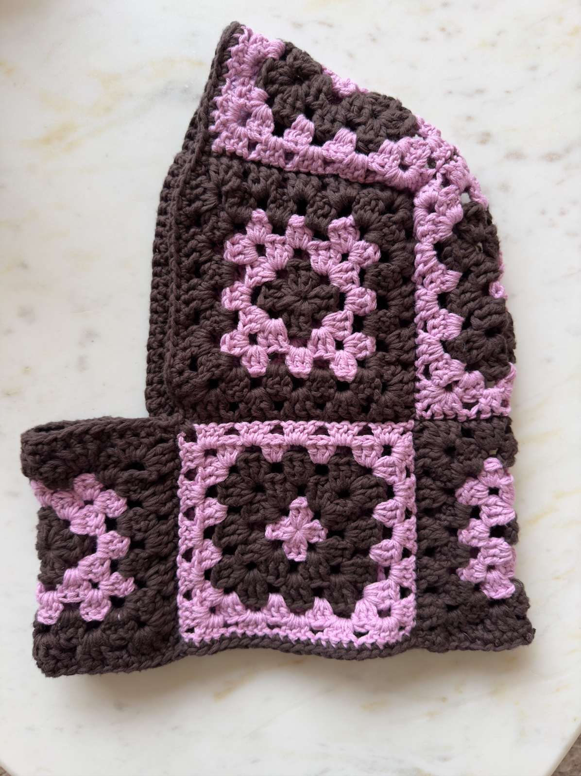 Shows our crocheted umi balaclava which is made of pink and brown granny squares. Made by The Woollers