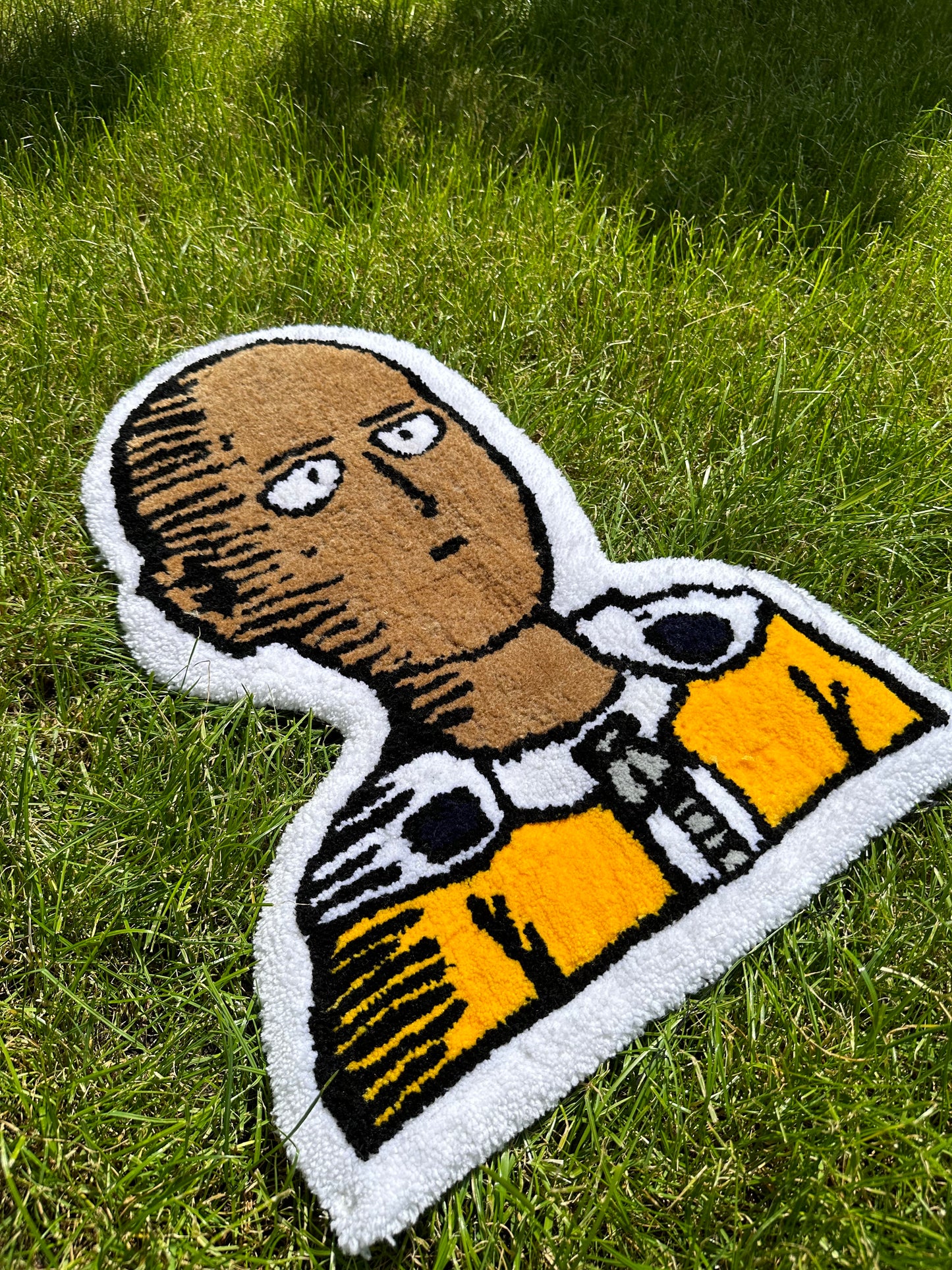 Shows our tufted SAITAMA Rug, which features Saitama's signature expression in his face